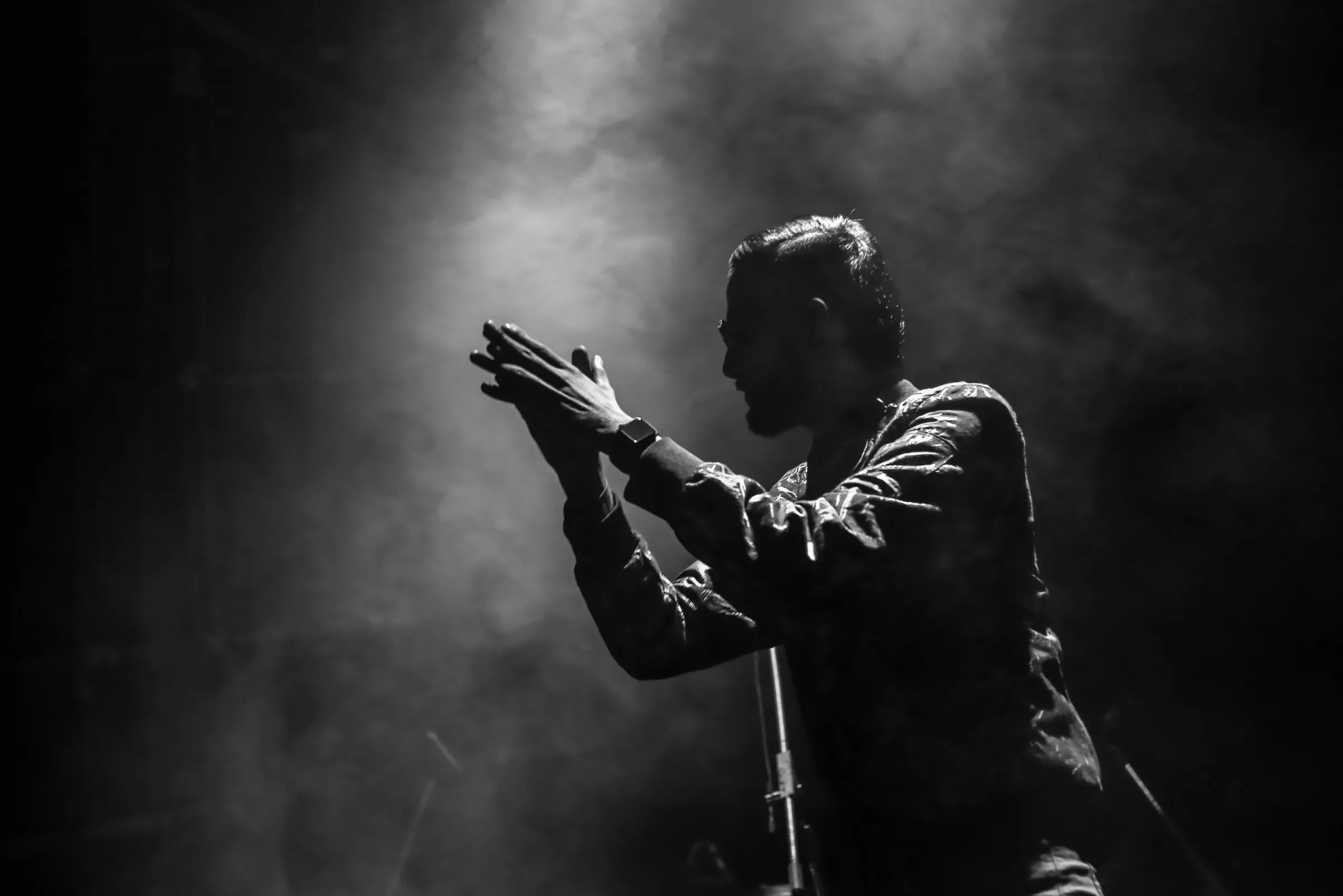 Sapta on stage in smoke and white light, hands raised